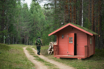 Papier peint photo Chasser Chasseur quittant le chalet rouge  © scharfsinn86