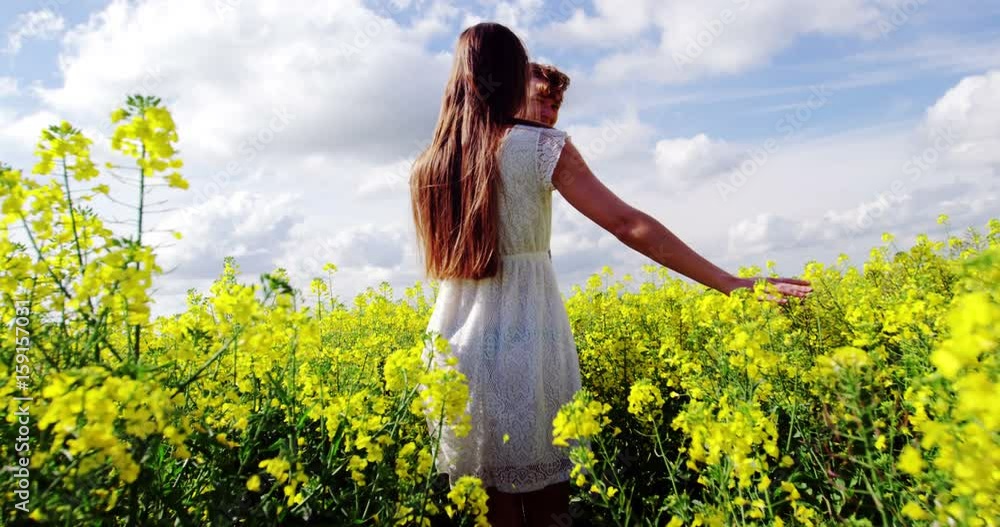 Romantic couple holding hands while walking in field Romantic couple holding hands while walking in field