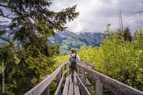 Wanderer auf Holzsteg im wiederaufgeforsteten Naturschutzgebiet photo