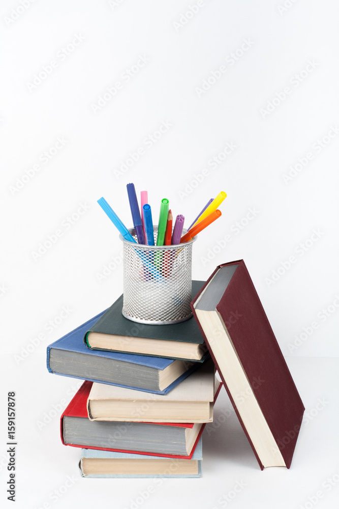 Open book, hardback colorful books on wooden table, white background. Back  to school. Pens, pencils, cup. Copy space for text. Education business  concept. Stock Photo