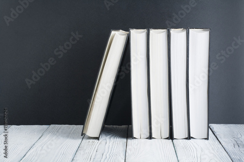 Open book, black, Whitel books on wooden table, black board background. Back to school. Education business concept.