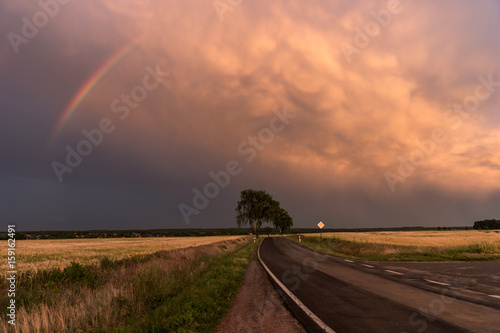 Dramatic beautiful sunset with rainbow in the sky