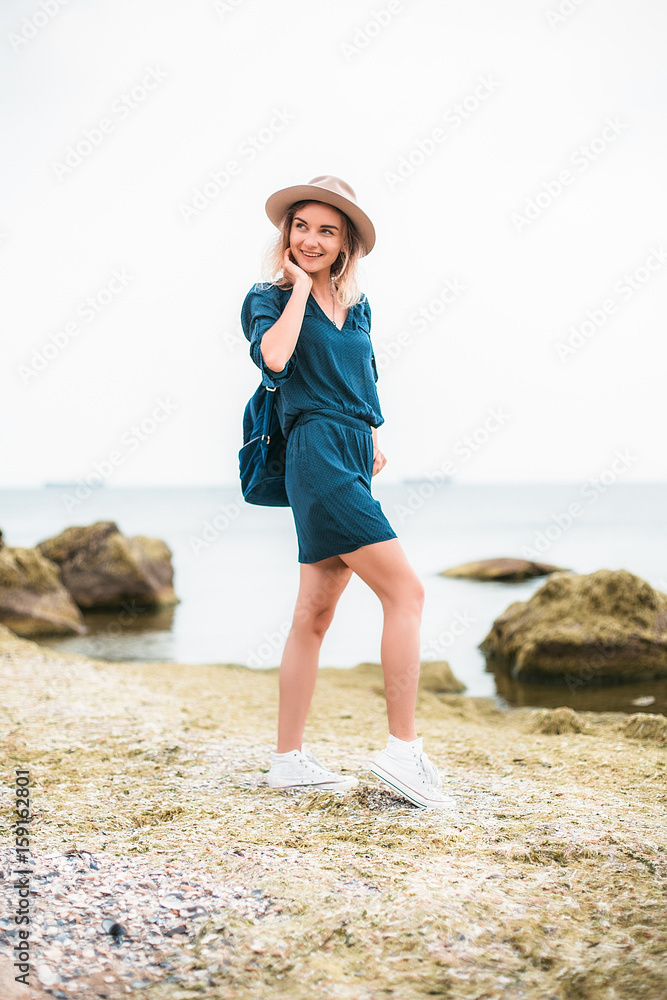 Summer portrait of young hipster woman in a brown hat having fun on the sea.young slim beautiful woman,bohemian outfit,indie style, summer vacation,sunny,having fun, positive mood,romantic