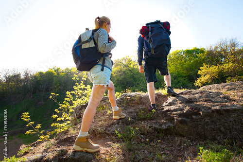Couple backpackers hiking in the forest during summer. Travel, hiking, backpacking, tourism and people concept