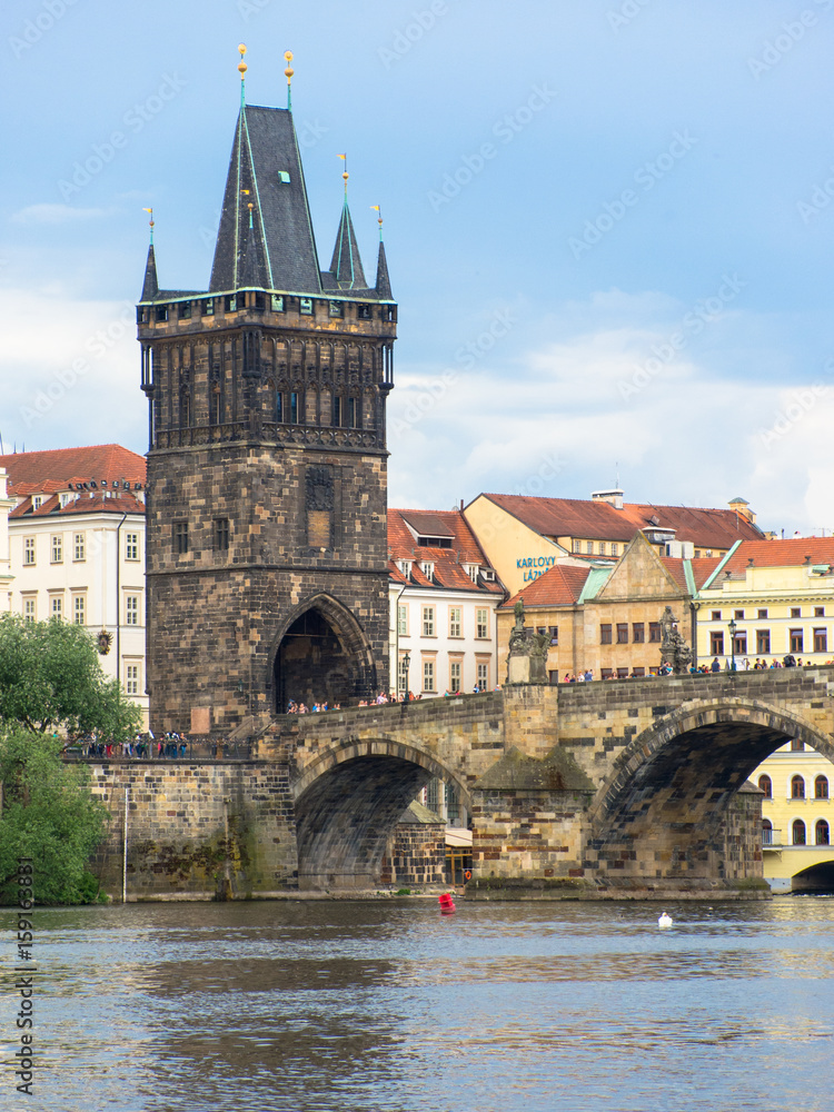     prague old town tower at the end of charles bridge and its reflection in vltava river 