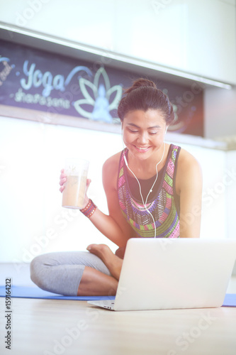 Sporty smiling woman using laptop in bright room. Woman. Lifestyle photo