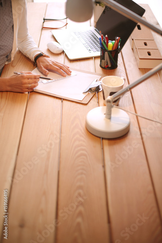 Young female working sitting at a desk. Businesswoman. Drawing. Student. Workplace. Desk.