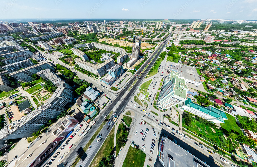 Aerial city view with crossroads and roads, houses, buildings, parks and parking lots, bridges. Helicopter drone shot. Wide Panoramic image.