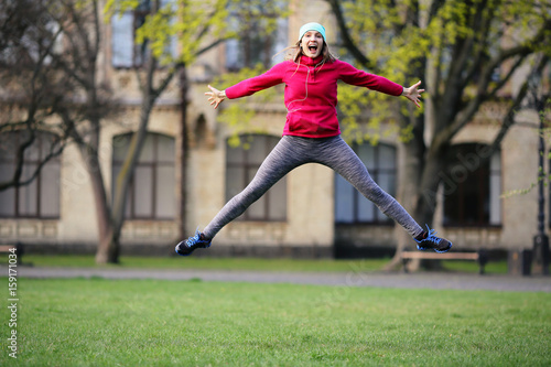 Beautiful happy young woman jumping on the grass, healthy lifestyle, running, morning, happiness