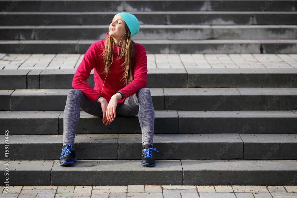 Sport beautiful young woman sitting on the steps, urban style, sports, healthy lifestyle Sport beautiful young woman sitting on the steps, urban style, sports, healthy lifestyle