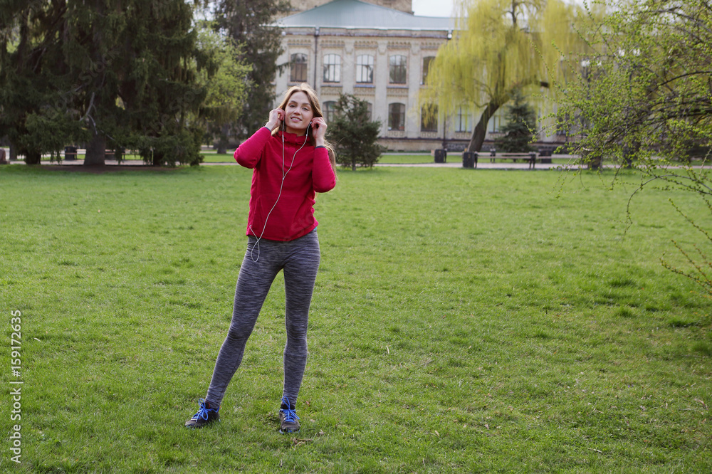 Beautiful smiling sport woman in training, background building, park, trees, healthy lifestyle