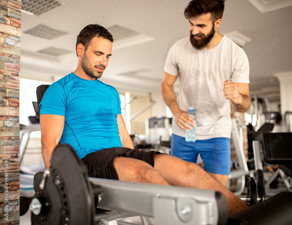 Obraz premium Personal trainer working with his client in gym