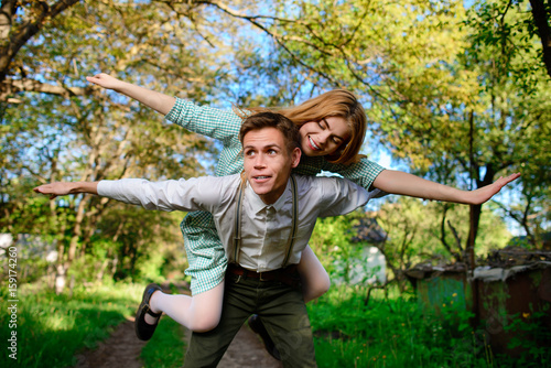 Portrait of happy couple raising their hands in open air.