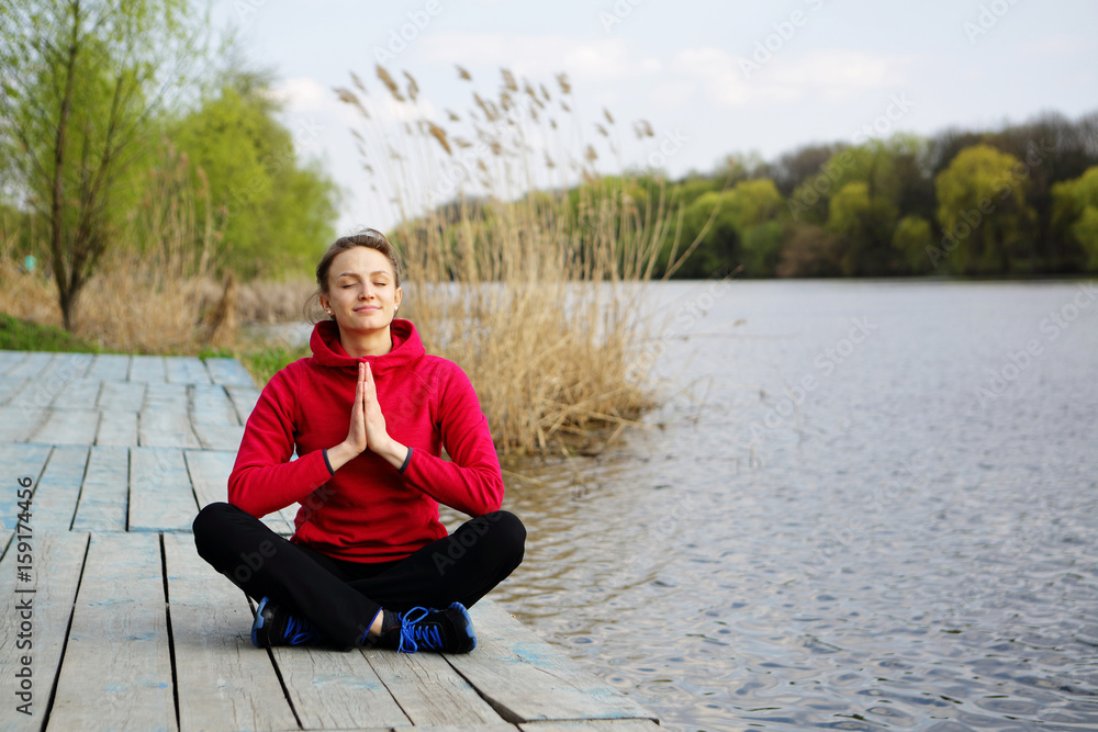 Fototapeta premium Meditating woman with praying hands yoga exercise outdoor, natural background, river