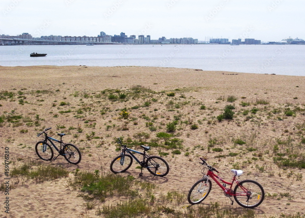 Fototapeta premium Relax on the beach. Cyclists lie on the sand.