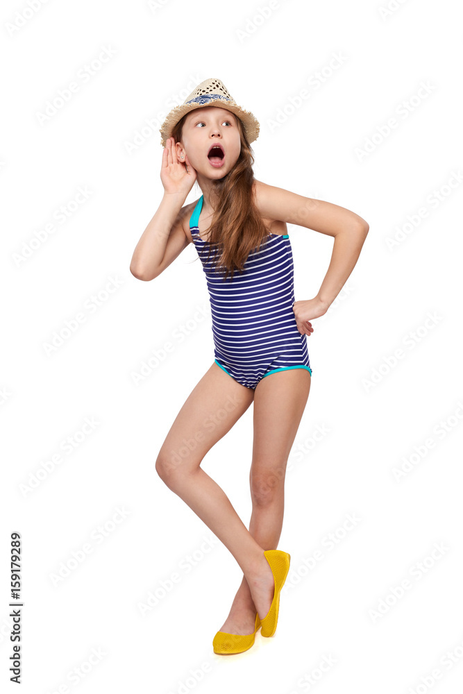 Surprised full length child girl in swimsuit and summer hat with hand on ear listening, over white background Surprised full length child girl in swimsuit and summer hat with hand on ear listening, over white background