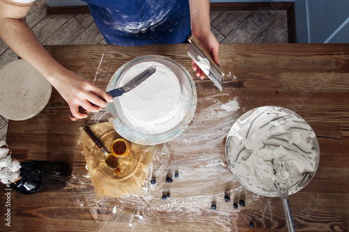 Obraz na plátně Chef decorating a delicious cake with cream
