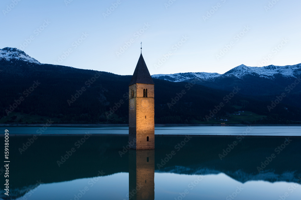 Kirchturm im Reschensee bei Graun im Vinschgau nach Sonnenuntergang