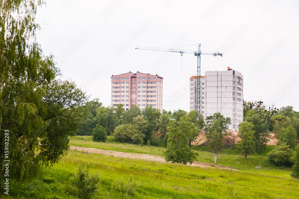 Construction of new house or building. General view. Unfinished cement building in the summer. The introduction of urbanization into nature. Capital construction in Ukraine Construction of new house or building. General view. Unfinished cement building in the summer. The introduction of urbanization into nature. Capital construction in Ukraine