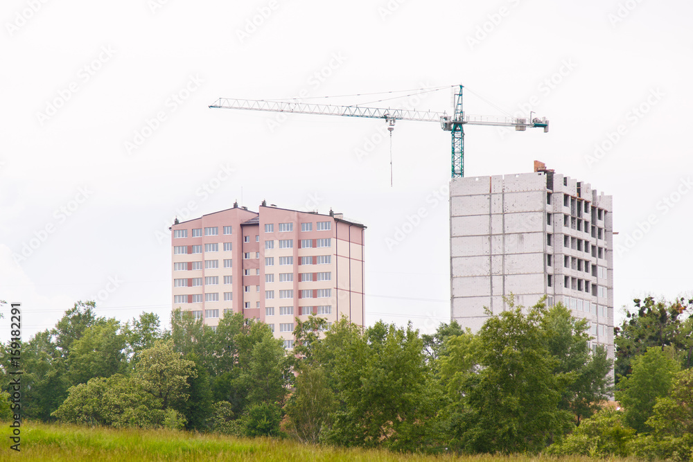 Construction of new house or building. General view. Unfinished cement building in the summer. The introduction of urbanization into nature. Capital construction in Ukraine Construction of new house or building. General view. Unfinished cement building in the summer. The introduction of urbanization into nature. Capital construction in Ukraine