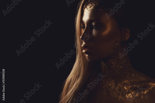 Fashion photo of a beautiful young woman. close up of beauty gold portrait girl. copyspace