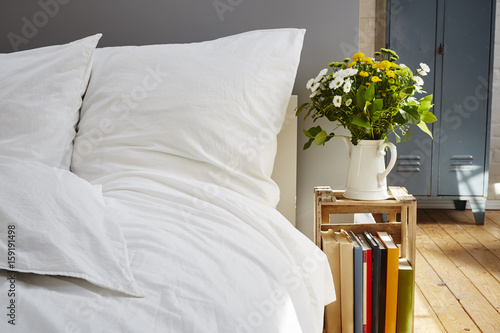 white bed linen morning light fresh flowers industrial photo