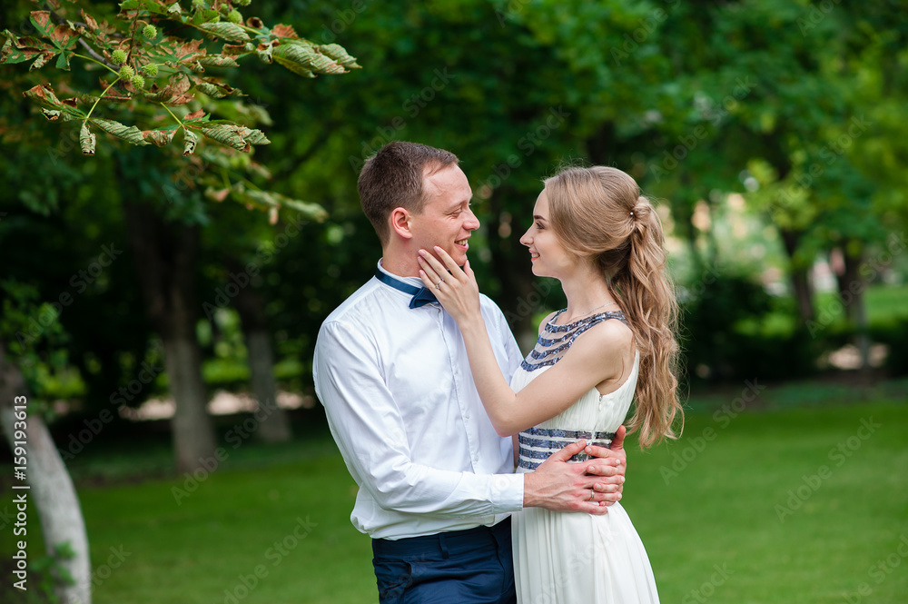 Fototapeta premium A married couple is walking and hugging in the park.