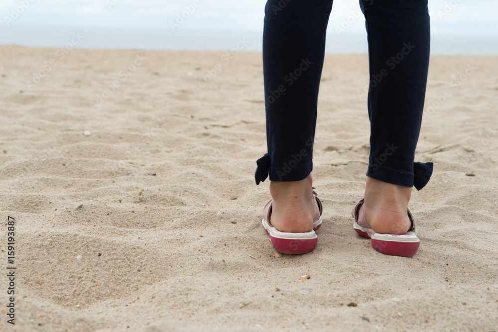 girl child standing face ocean beach sand