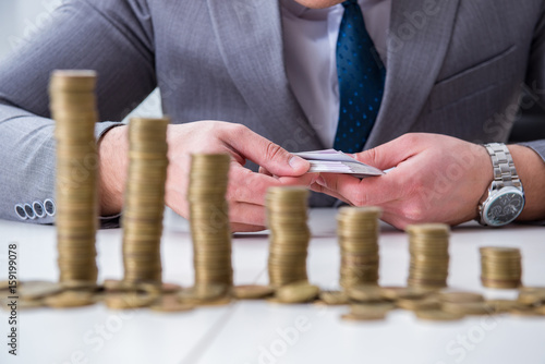 Businessman with golden coins in business growth concept