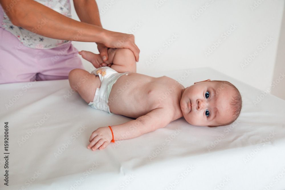 The doctor massages the leg of a child on a white background. Baby massage The doctor massages the leg of a child on a white background. Baby massage