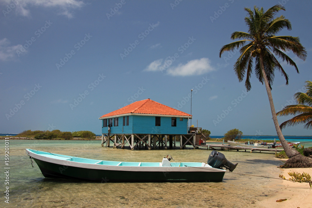 Fototapeta premium Cabins on stilts on the small island of Tobacco Caye, Belize, Central America