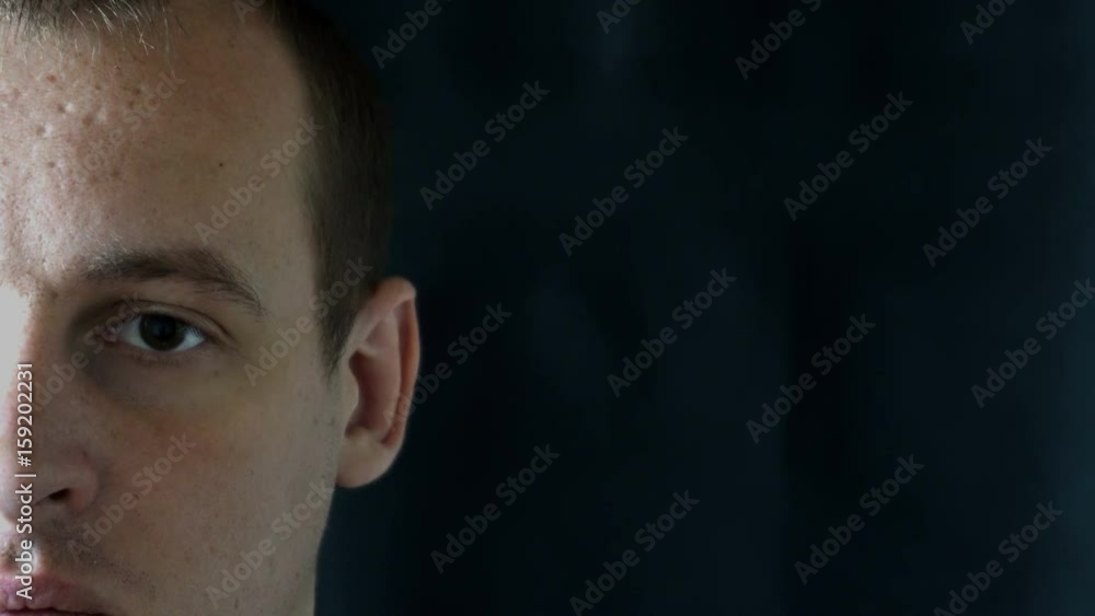 portrait of a young man staring at camera,black background. portrait of a young man staring at camera,black background.