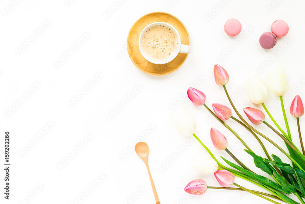 Cup of coffee, lilac and white tulip flowers, macaroon cake on white background. Flat lay, top view Cup of coffee, lilac and white tulip flowers, macaroon cake on white background. Flat lay, top view