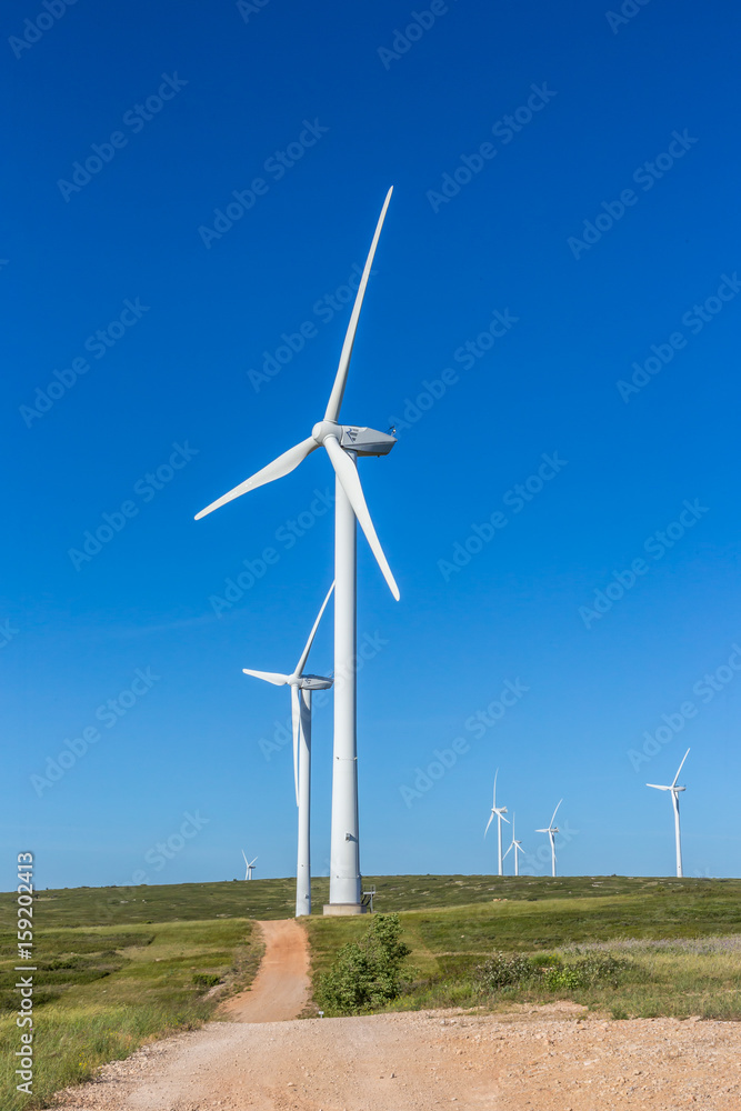 un paysage verticale avec des éoliennes sur le chemin de crête d'une colline un paysage verticale avec des éoliennes sur le chemin de crête d'une colline