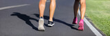 Fitness runners running road to weight loss banner - couple of young people jogging together - crop of legs and running shoes.