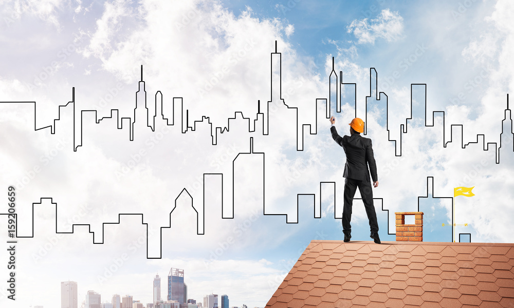 Man architect draw silhouette of modern city on blue sky. Mixed media