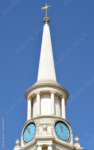 White spire with clock faces against clear blue sky