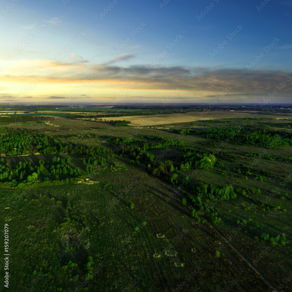 Beautiful view of the fields with trees on it at sunset. Aerial view. From above. Picture taken using the copter.