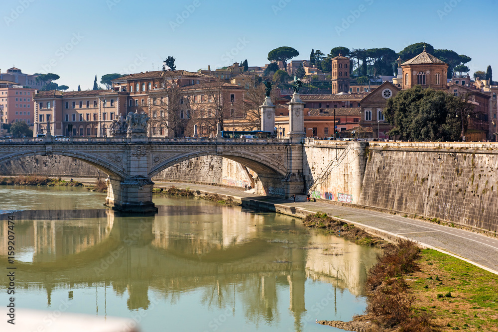 Rome city. View from Saint Angelo bridge along Tiber River on stone bridge Vittorio Emanuele II. Ponte Vittorio Emanuele II. Rome cityscape. Italy