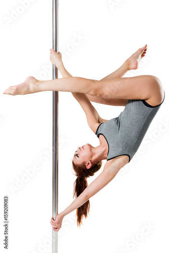 Beautiful pose slim girl athletes on a pylon on a white background
