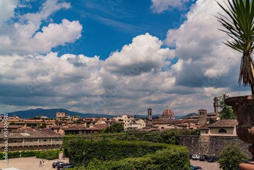 The skyline of Florence seen from the Boboli Gardens with puffy clouds in the sky.