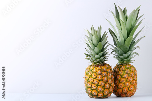 Ripe pineapples on grey background