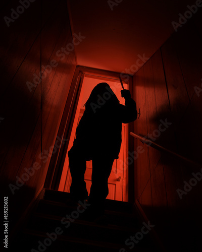 Scary Dark Killer Man with Knife on Stairs photo
