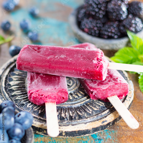 Fresh summer wild blueberries and brambleberry, home made sorbet ice cream popsicles on stone plate