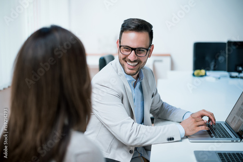 Portrait of happy businessman in office, smiling.