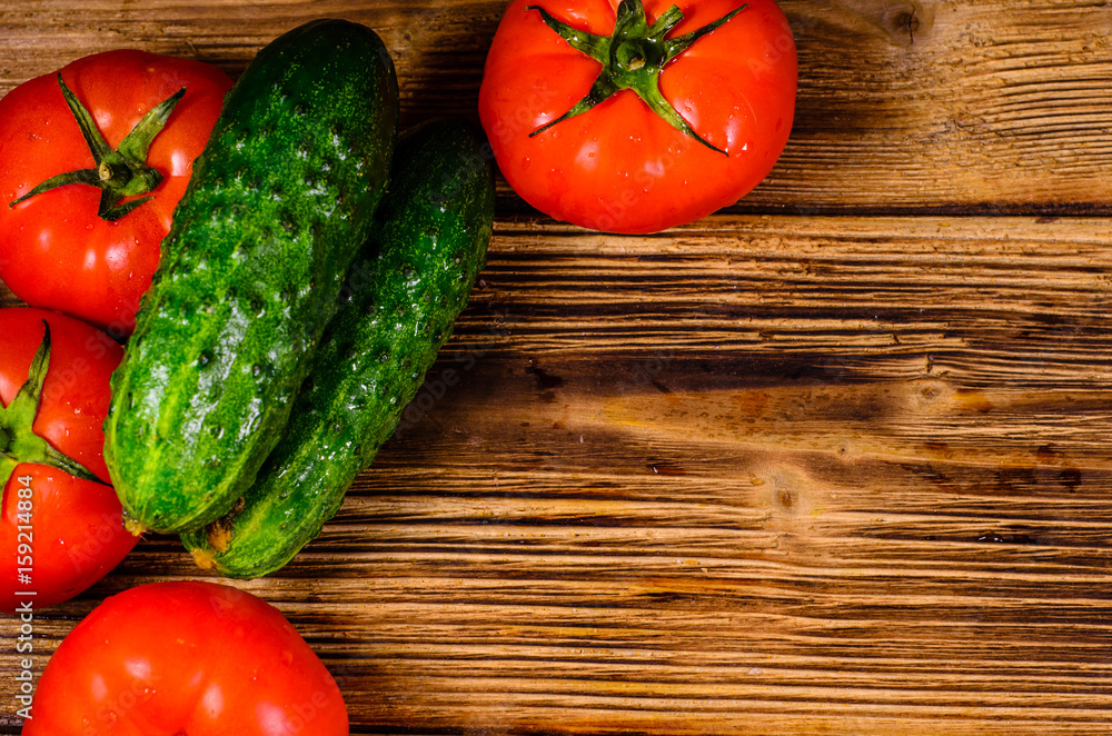 Ripe tomatoes and cucumbers on wooden table. Top view Ripe tomatoes and cucumbers on wooden table. Top view