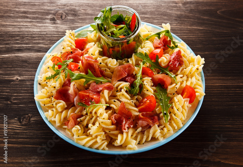 Pasta with tomato sauce on wooden table 