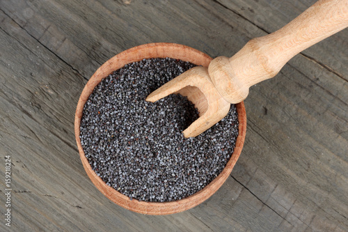 poppy seeds in wooden bowl on wooden background with copy space. top view photo