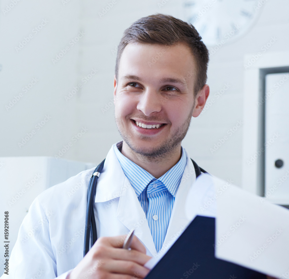 Doctor and patient are discussing something. Smiling handsome male doctor talking to patient. Doctor and patient are discussing something. Smiling handsome male doctor talking to patient.