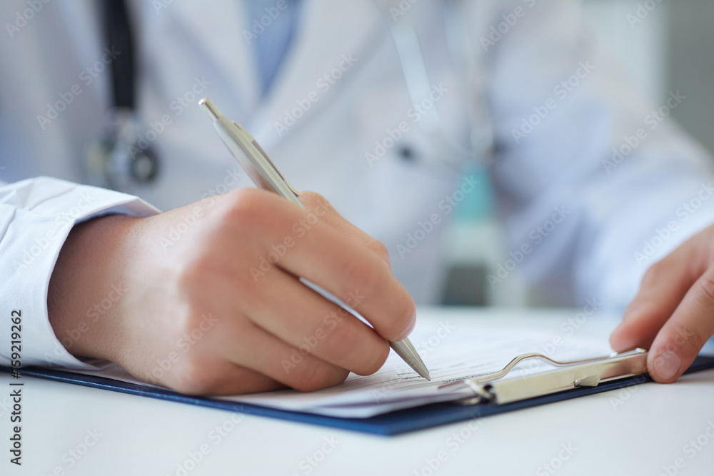 Male medicine doctor hand holding silver pen writing something on clipboard closeup. Ward round, patient visit check, medical calculation and statistics concept. Physician ready to examine patient - obrazy, fototapety, plakaty 